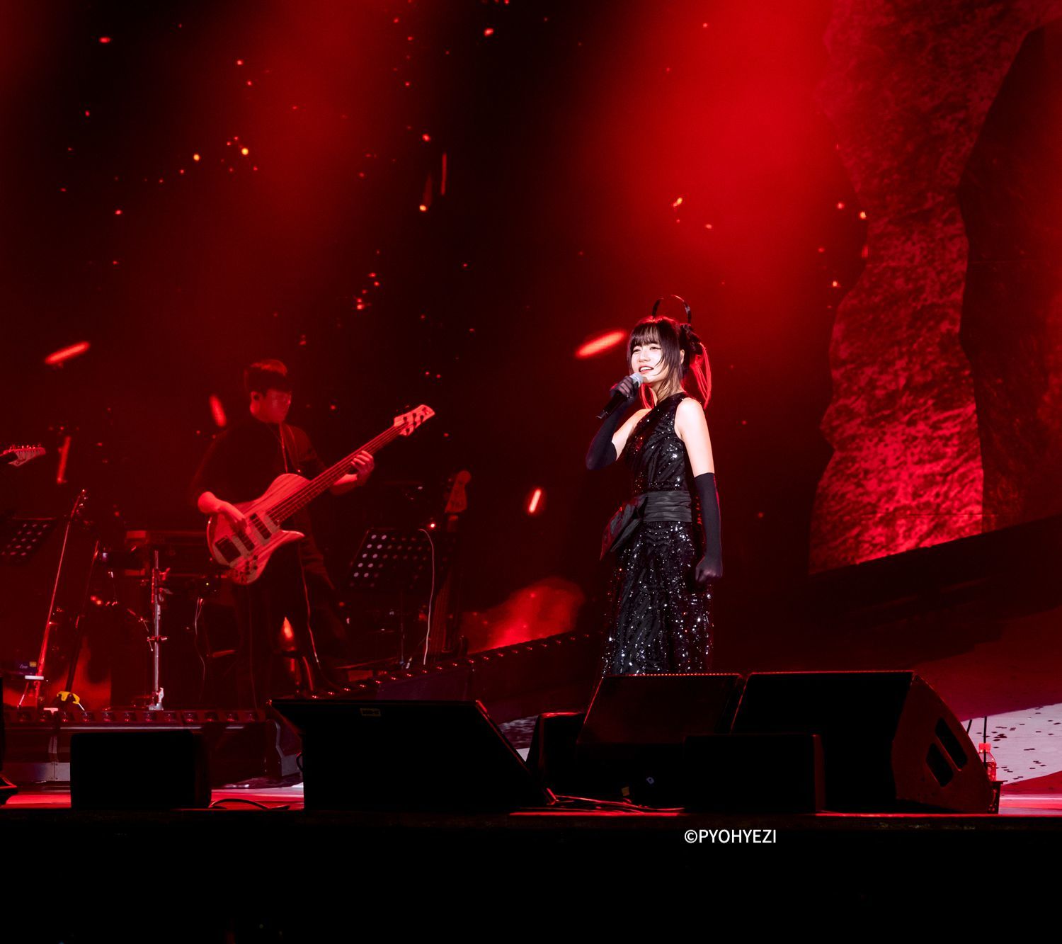 ライブパフォーマンスの写真：ギター、ベース奏者と歌う シム･ギュソン。単独コンサート「Monster 」より。